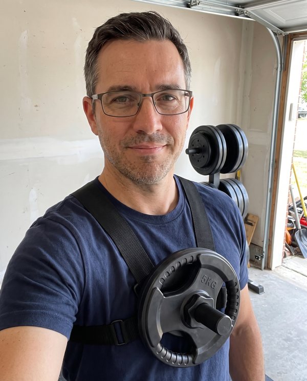 A man in his forties wearing the Kensui EZ-VEST V2 Lite with a single iron plate on the chest post