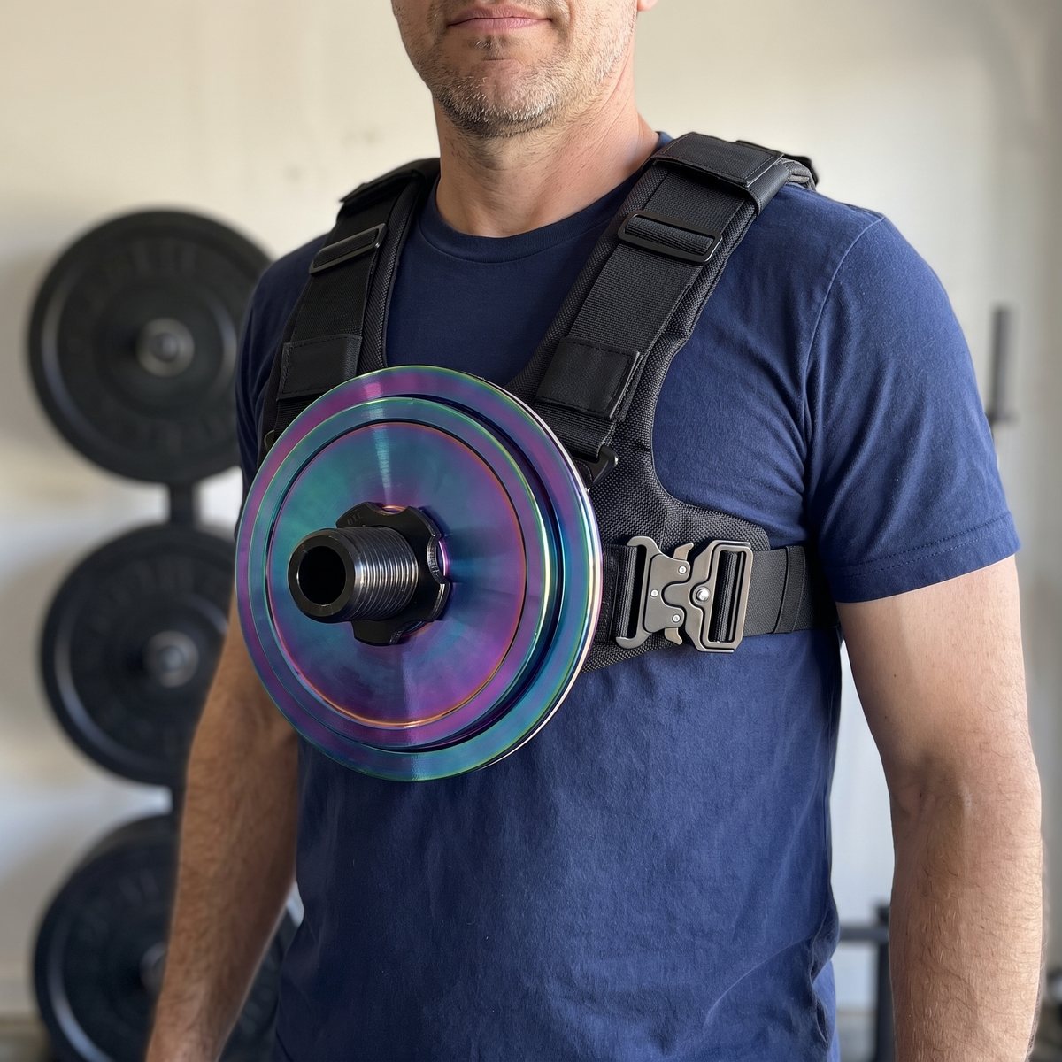 Close-up of the chest post of a Kensui EZ-VEST worn over a navy t-shirt, a single plate locked on with the collar, a plate tree behind