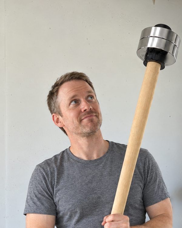 The author in his garage holding the wooden EZ-MACE PRO upright, looking up at the plates