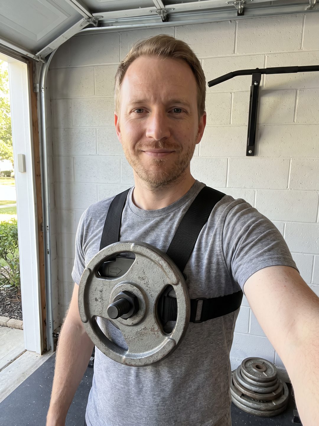 The writer in his garage wearing the EZ-VEST Lite with an old iron plate locked to the chest post