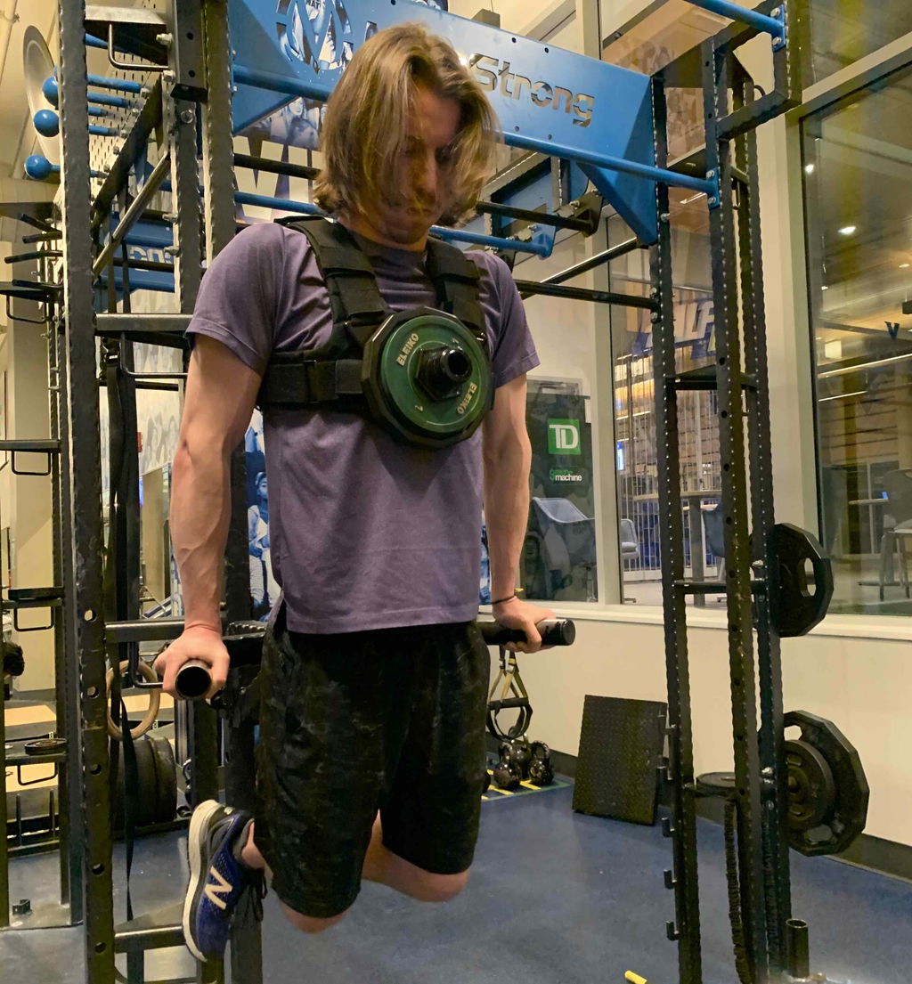 Weighted dip performed on a rack while wearing a loaded vest
