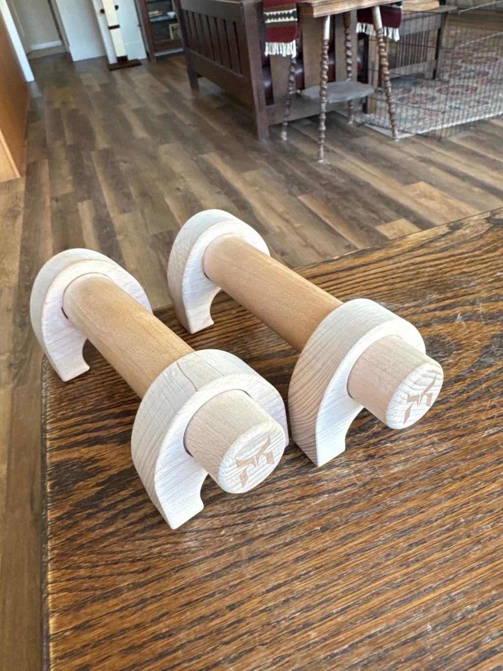 A pair of wooden parallettes on a hardwood floor in a living room