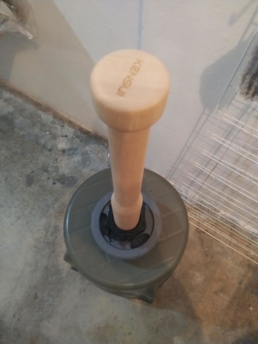 An owner's wooden EZ-CLUB PRO standing upright on a black weight plate, seen from above